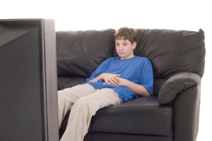 A teenage boy watching TV