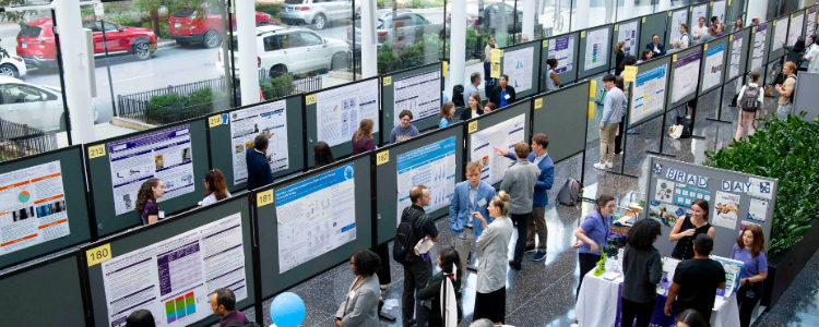 scientists present their posters at Research Day