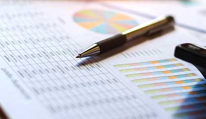 A pen atop a printout of a finance report