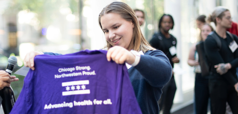 A participant holds up a shirt, displaying its tagline to the audience