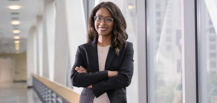 A woman with glasses smiling, posing for a picture 