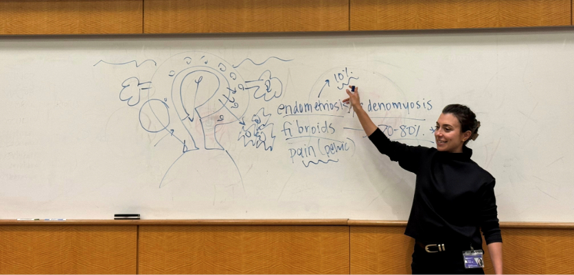 A woman drawing at a board