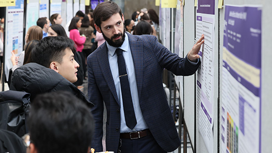 Student presenting their poster at research day