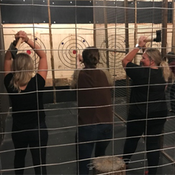 Another photo of residents and faculty at an axe-throwing event.