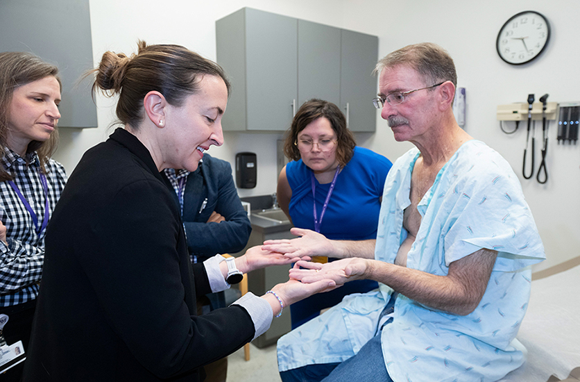 Medical faculty providing real-time coaching and formative evaluation to a participant during a bedside clinical encounter at the Center for Bedside Medicine.