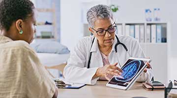 A doctor shows a patient a brain scan