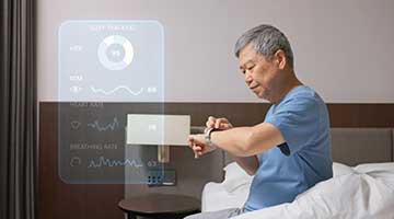 An older man checks his wearable monitor