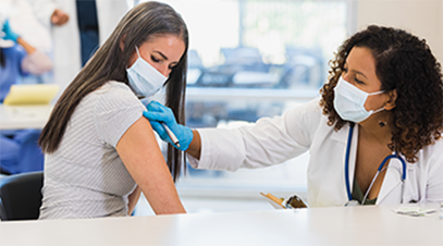 patient wearing a face mask receiving immunization from a masked healthcare provider