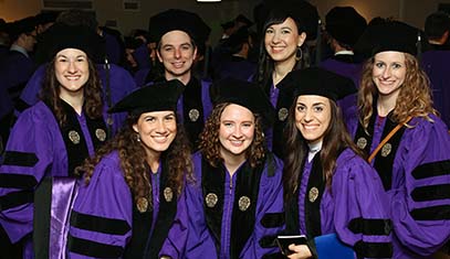 Seven PHD students with their cap and gown