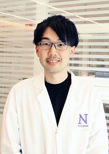 Shodai wearing a white lab coat