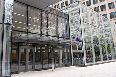 glass building entrance under bridge