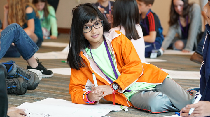 Child writing on a large piece of paper