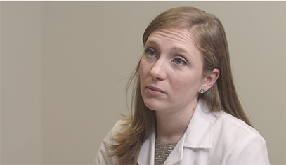 A physician in a white coat stares at a patient in a healthcare simulation.