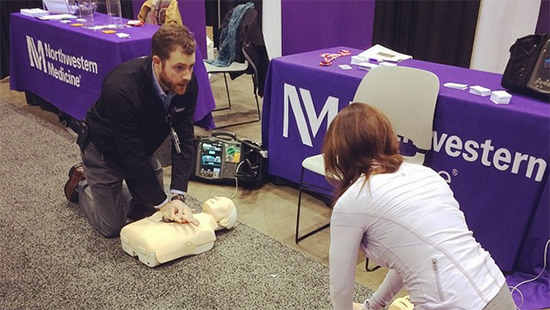 Two people completing CPR training on mannequins