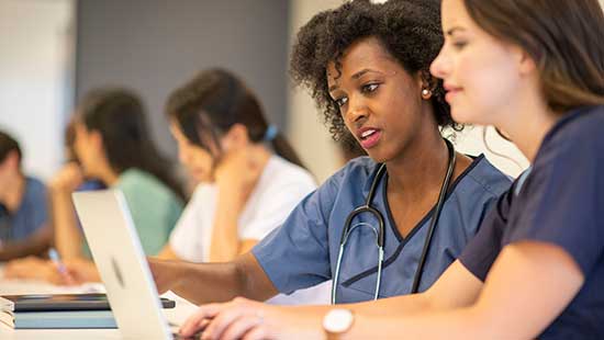 Clinicians speaking and looking at a computer