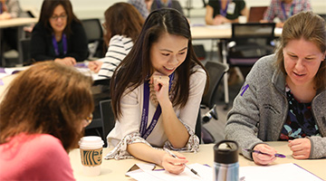 Professionals at a seminar gather around a table in discussion