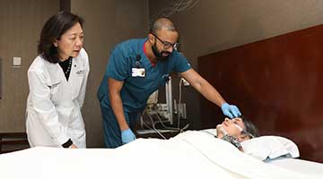 Clinicians check on a patient during a sleep study