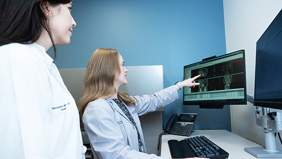 two researchers looking at a computer screen