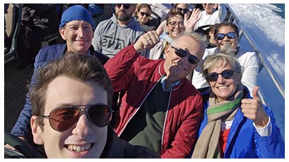 Image of a selfie with a group waving and another giving a positive thumbs up.