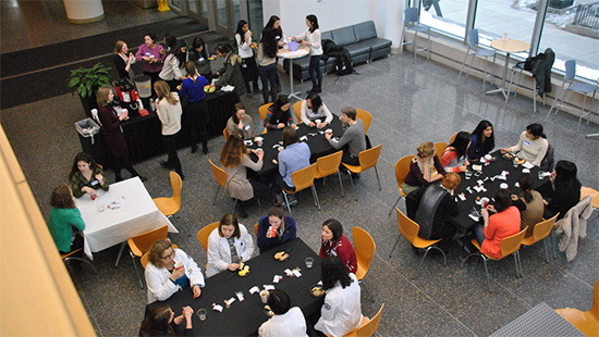 Faculty sit at tables at a past WFO event